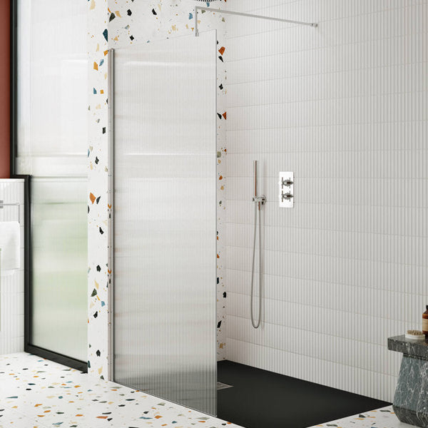 Hudson Reed fluted glass walk-in shower screen with aluminium profile and support bar, installed in a modern wet room.