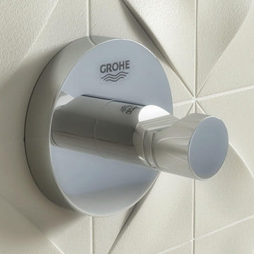 Grohe Essentials chrome wall or door hook mounted on a bathroom wall, ideal for hanging towels or robes.