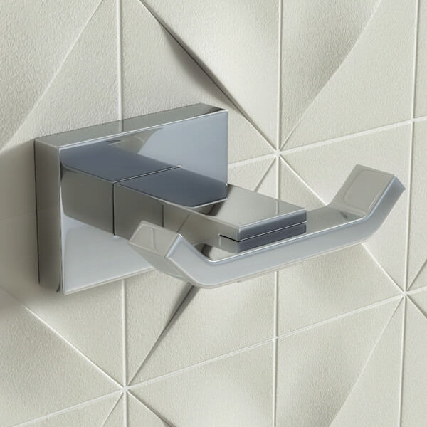 Contemporary chrome double towel hook by Vado Level, mounted on bathroom wall, designed for hanging towels and robes.