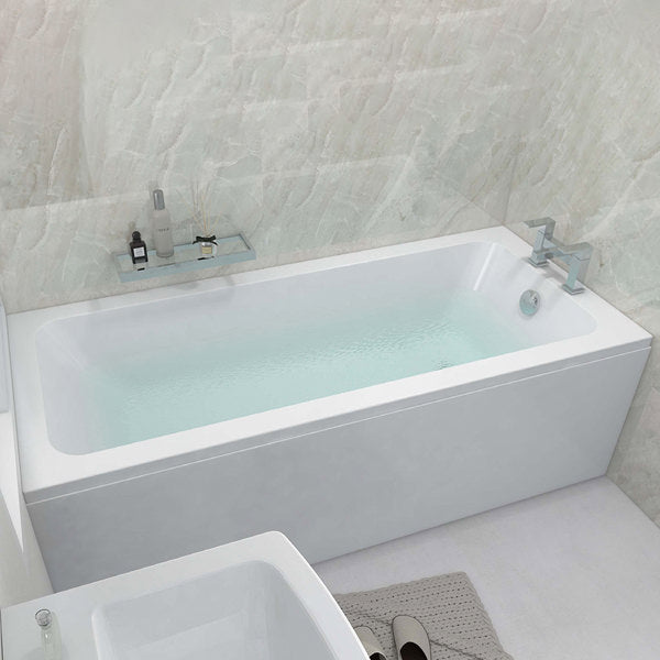 White IMEX Quadro single-ended bath with legs, 1300 x 700mm, sleek bathtub by Tuskan Tiles installed with leg set.